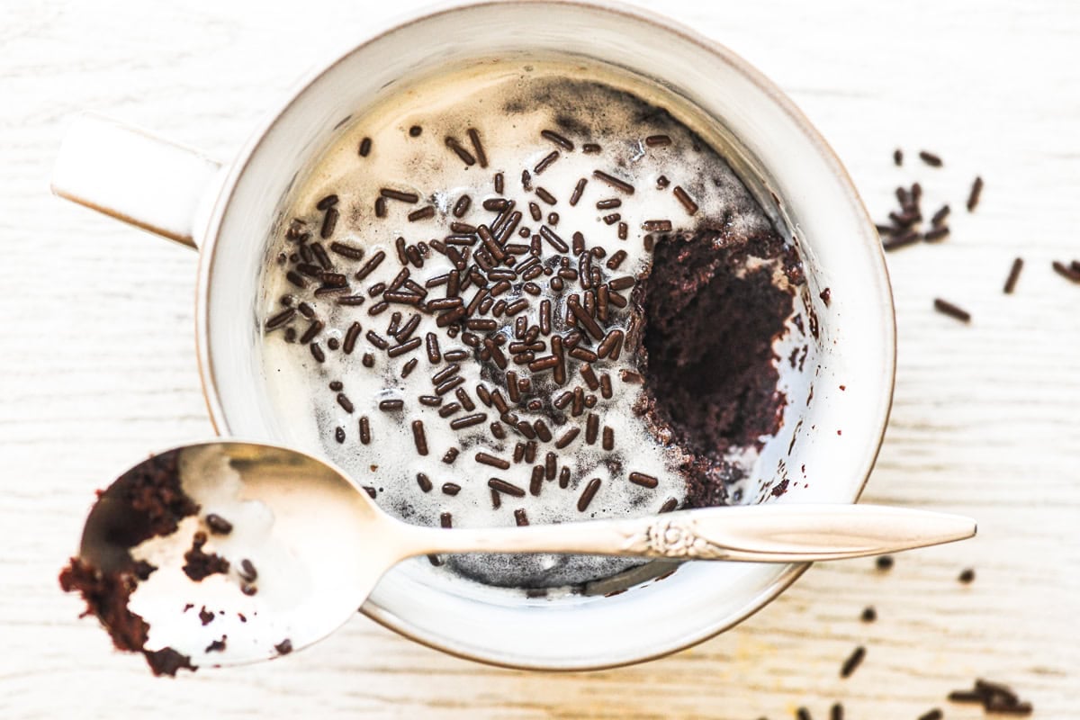 overhead look at a chocolate mug cake with spoon and bite taken.