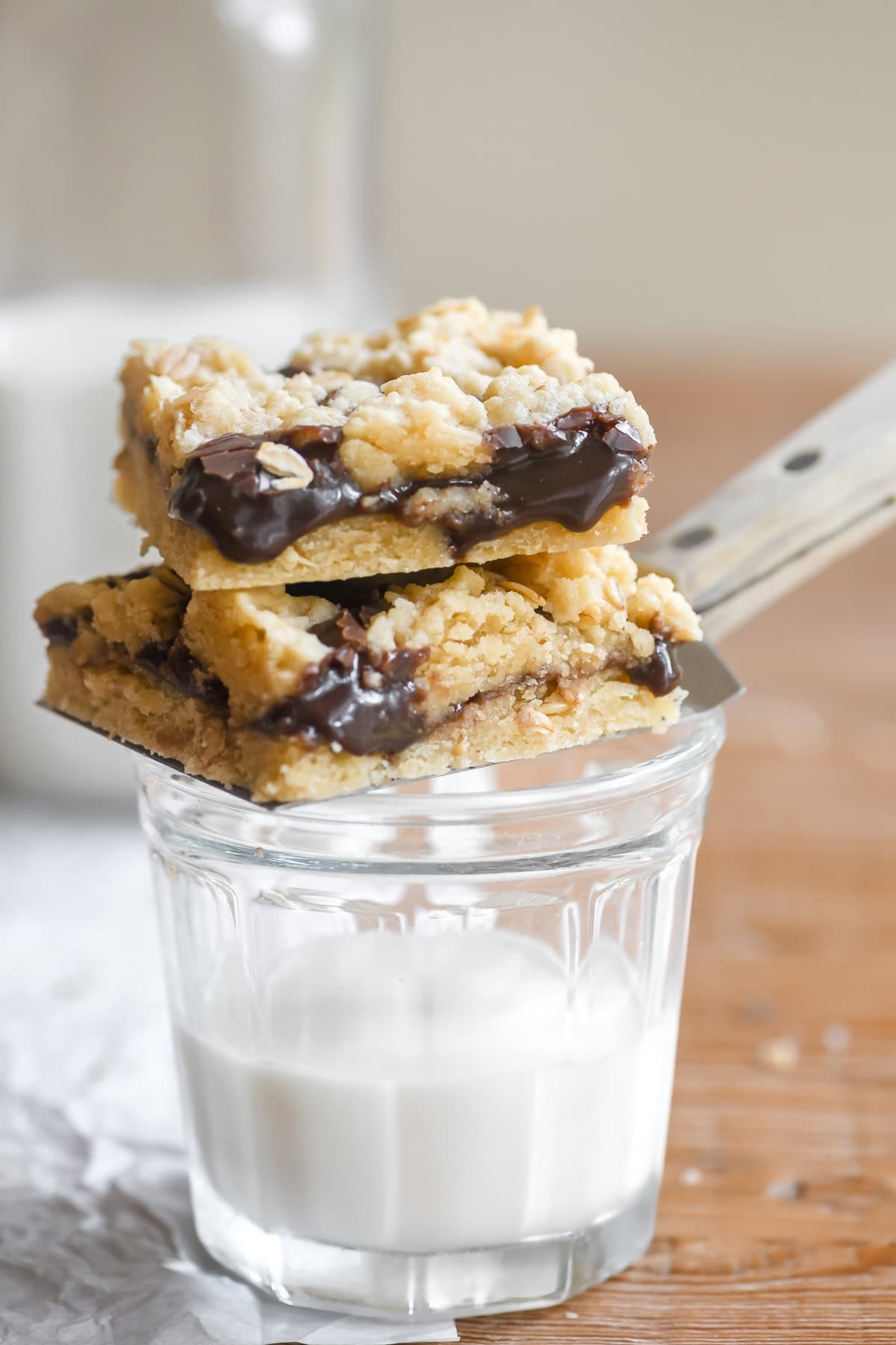 a stack of oatmeal fudge bars on a glass of milk.