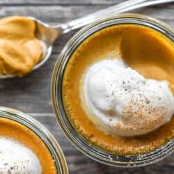 pumpkin pot de crème in small jars topped with maple whipped cream.