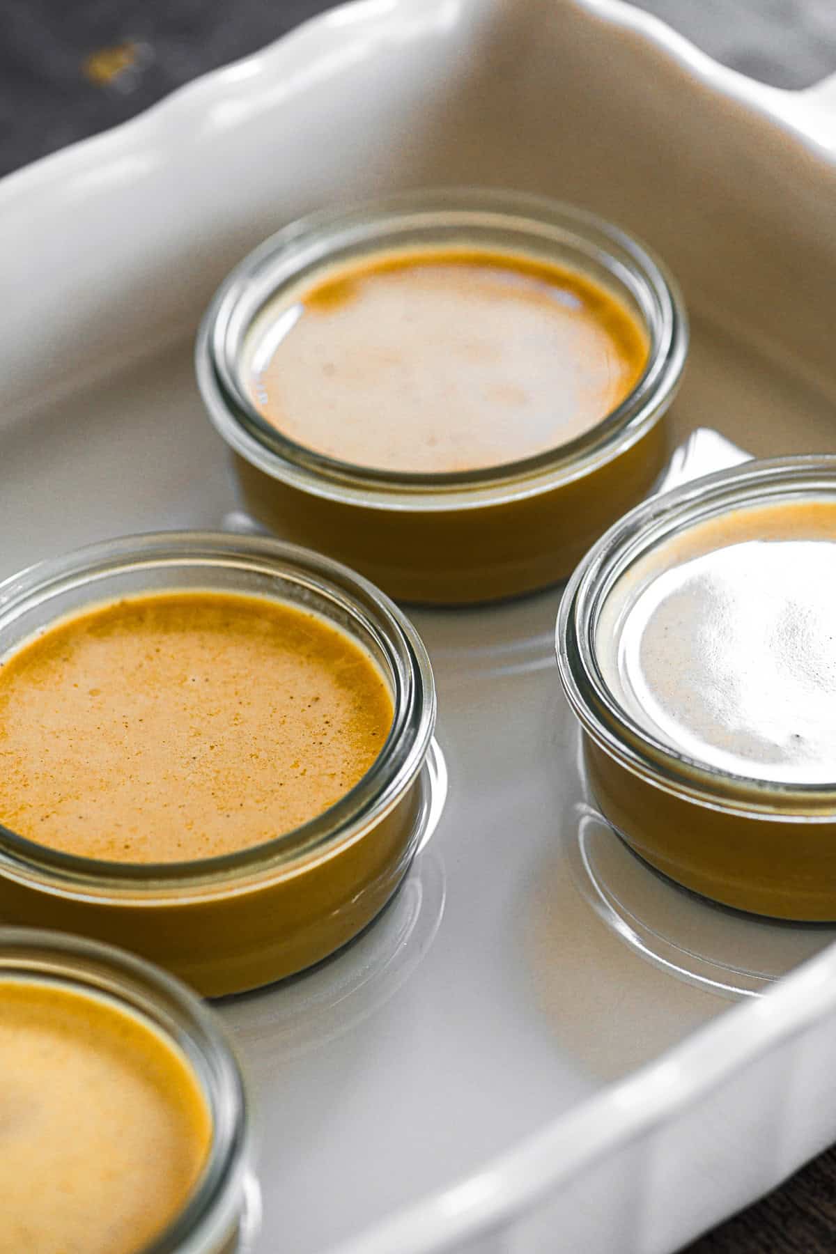 pumpkin pot de creme ready to bake in a shallow water bath.