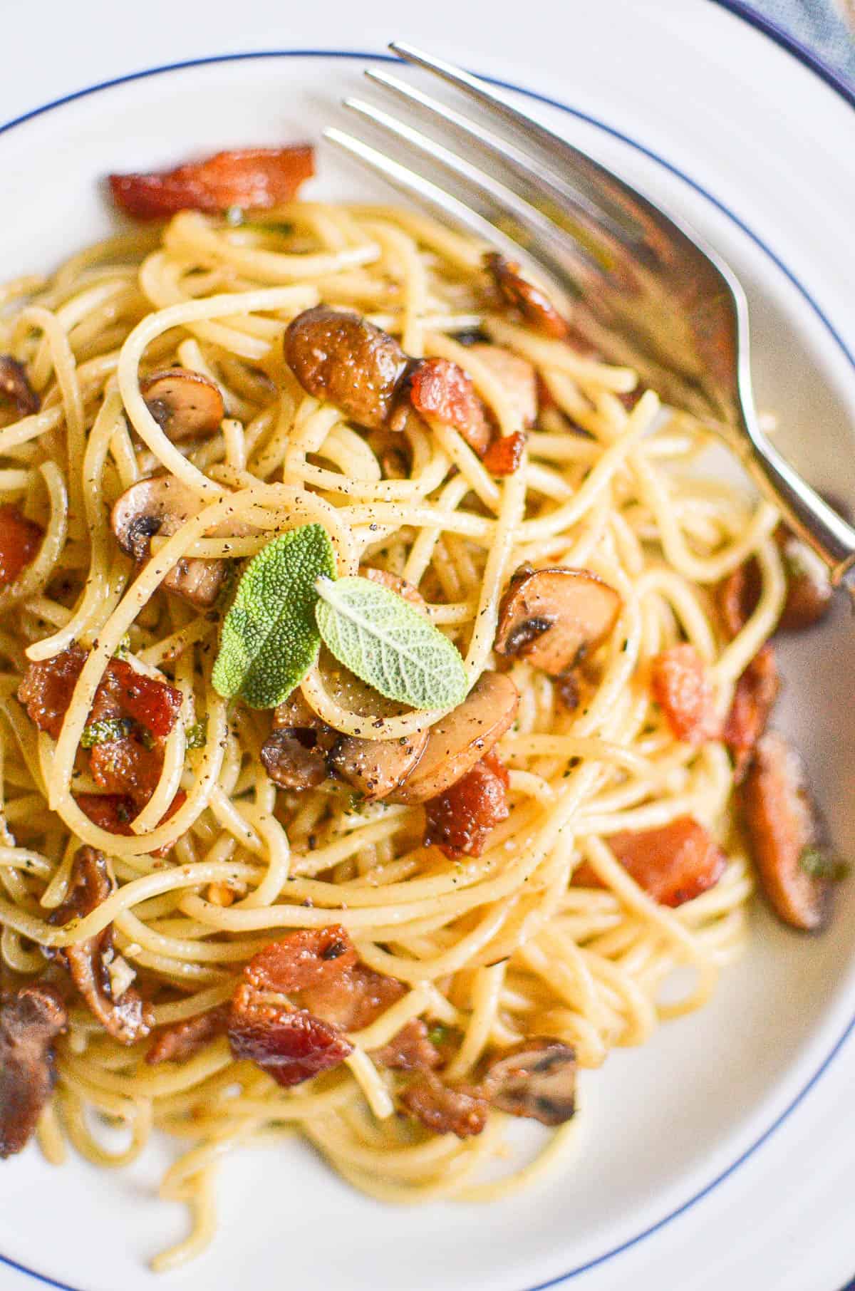 A bowl of bacon and mushroom spaghetti.