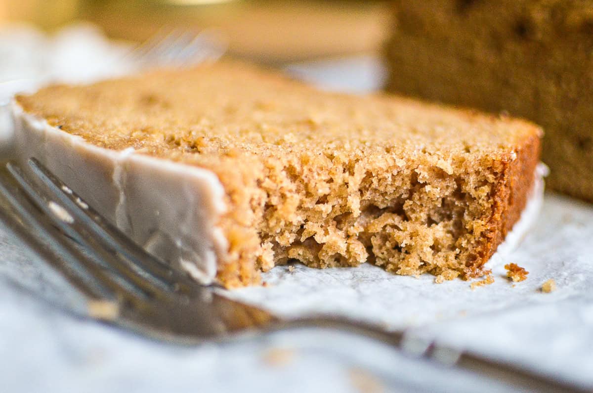A piece of spiced apple cake with a bite taken out.