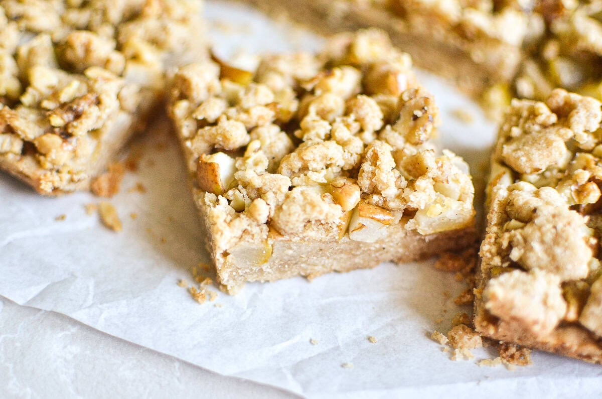 Pear crumble bars on a piece of white parchment paper.