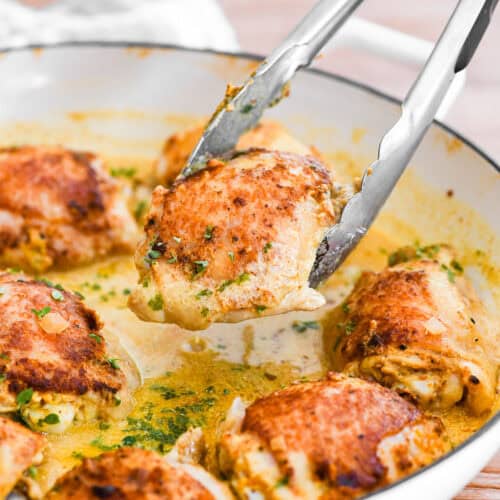 Taking a French mustard chicken thigh with tongs.
