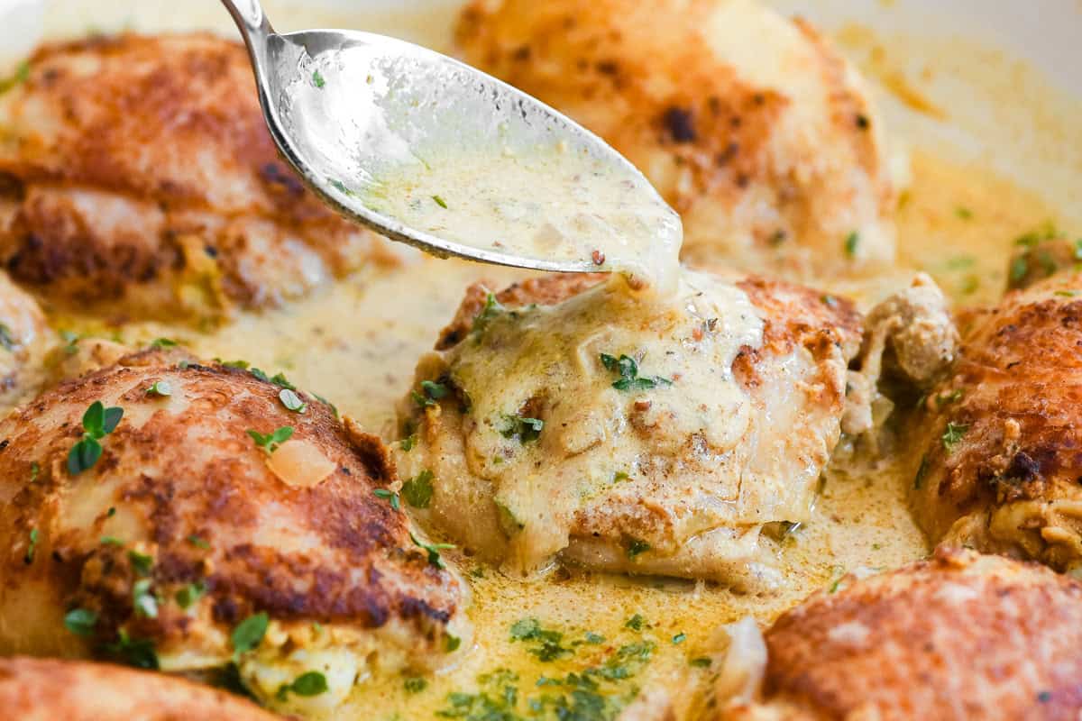 Spooning sauce over French mustard chicken thighs.