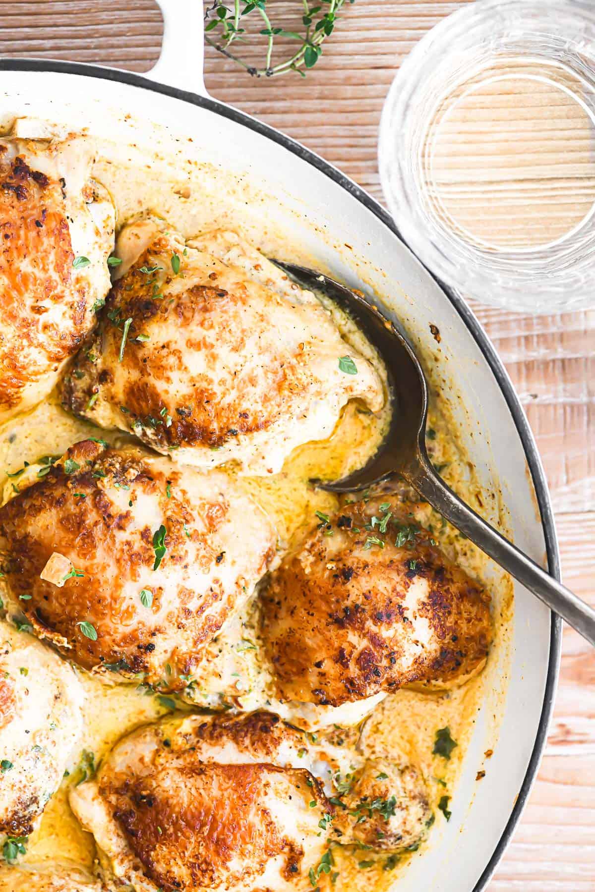 French mustard chicken in a white braising pan.
