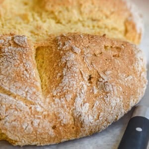 Irish yellowmeal soda bread loaf with cross cut in the top.