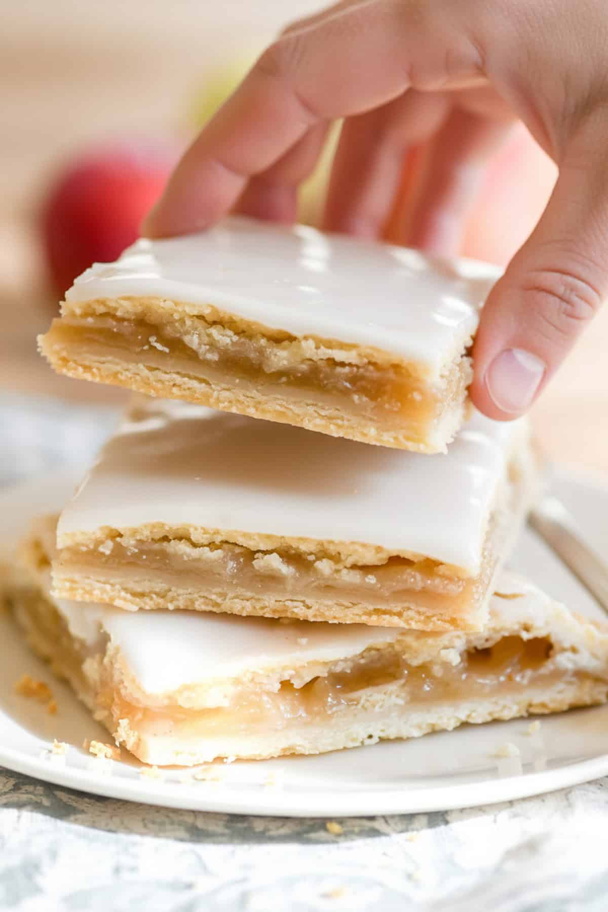 Taking an apple pie bar from a stack.