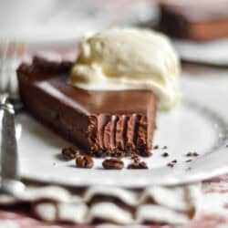 A slice of espresso ganache tart with fork marks.