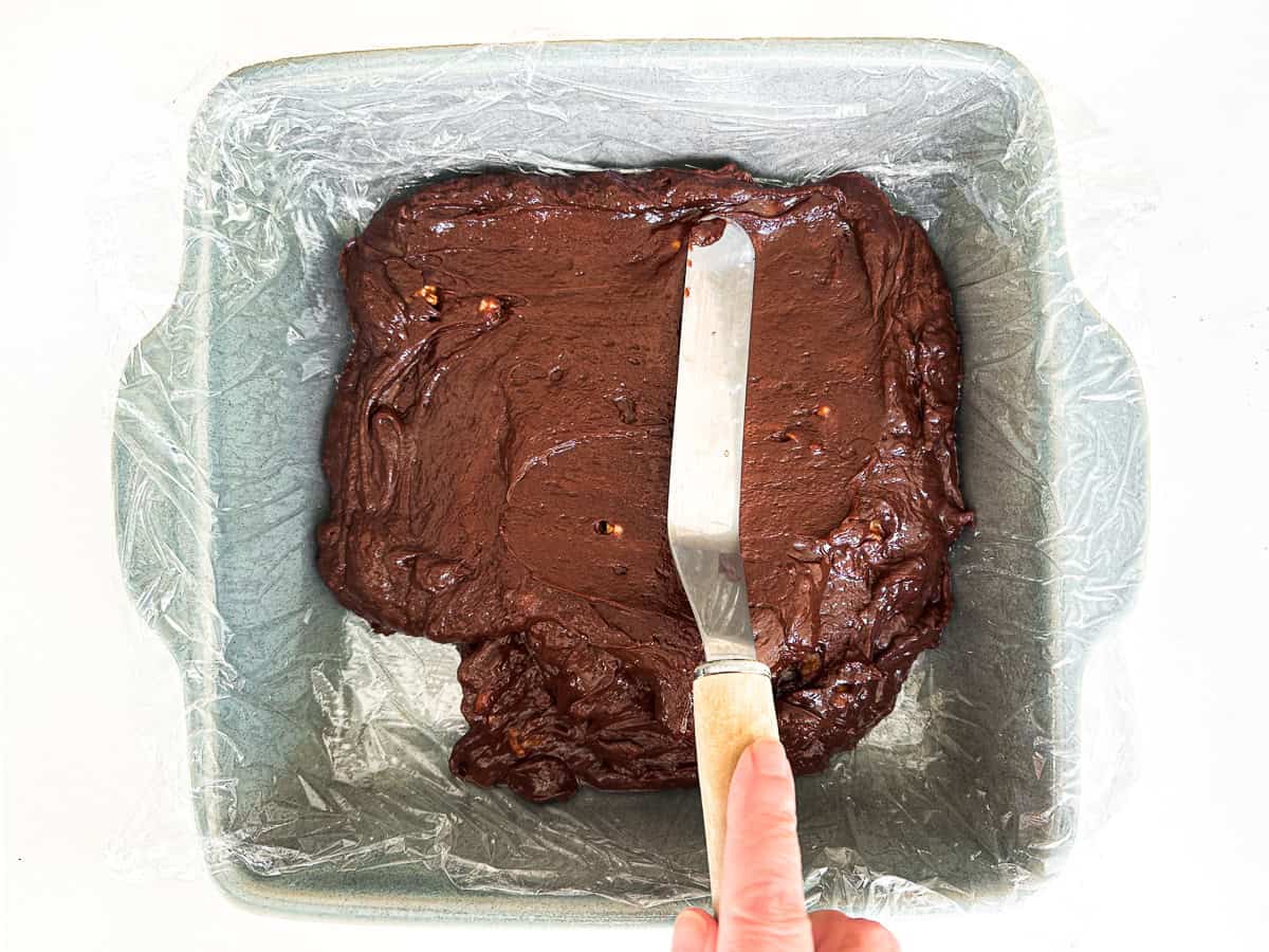 smoothing out microwave fudge in a lined 9x9 pan.