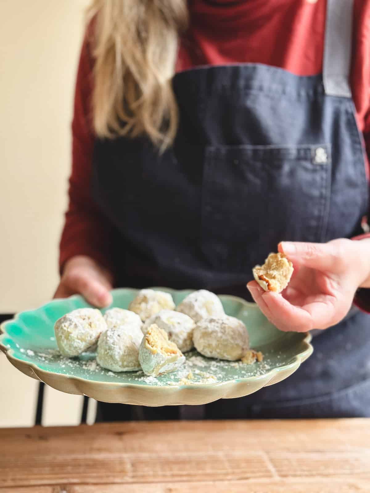 Sue holding a plate of walnut ginger butter balls.