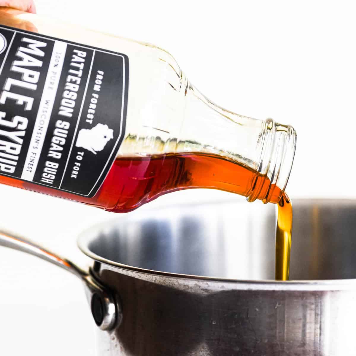 pouring maple syrup into a pan to make homemade maple sugar.