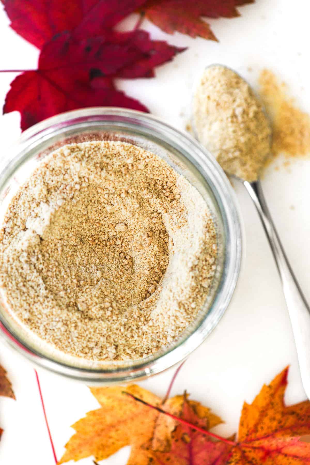 a jar of homemade maple sugar, with maple leaves