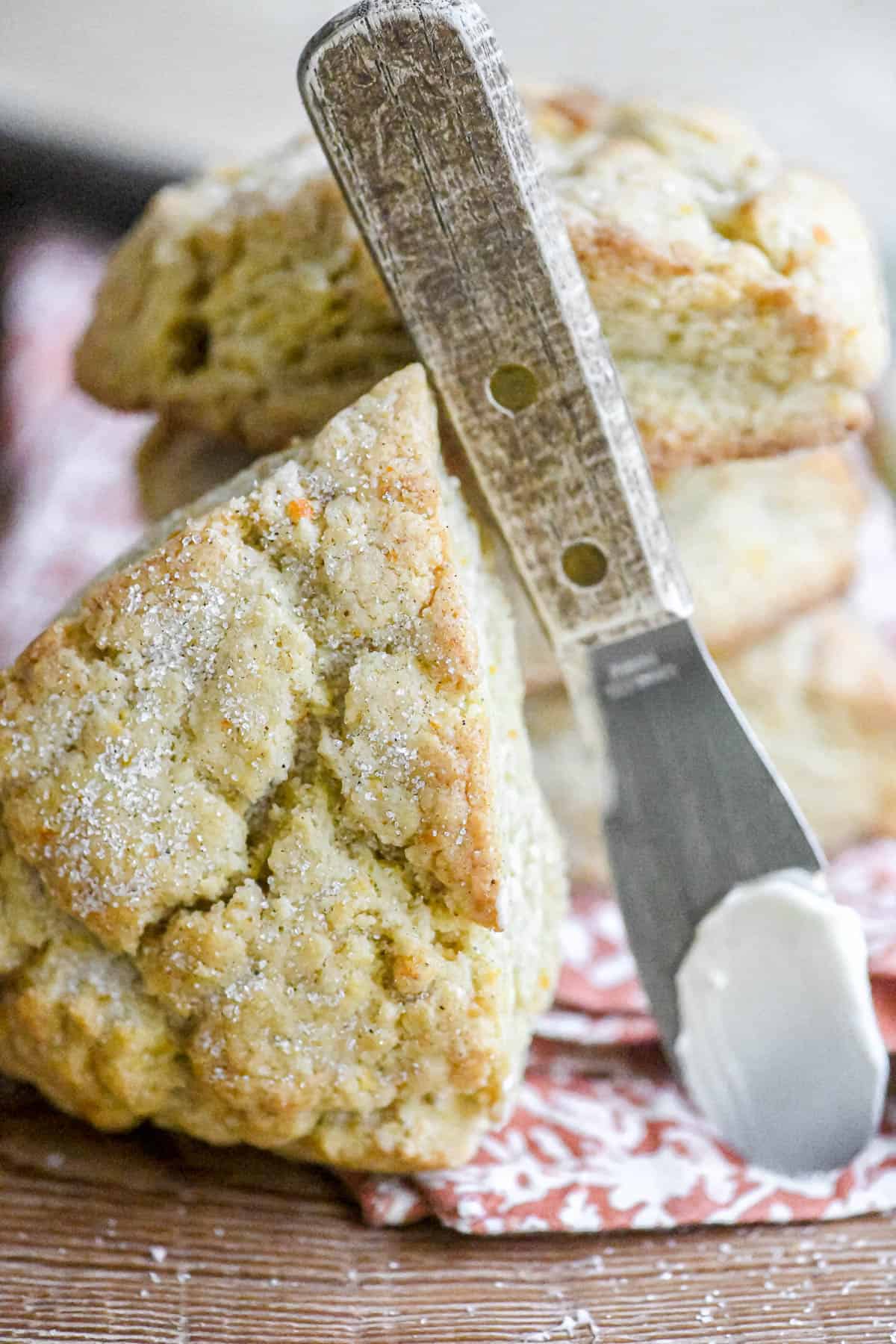 A stack of orange cardamom scones with a butter knife.