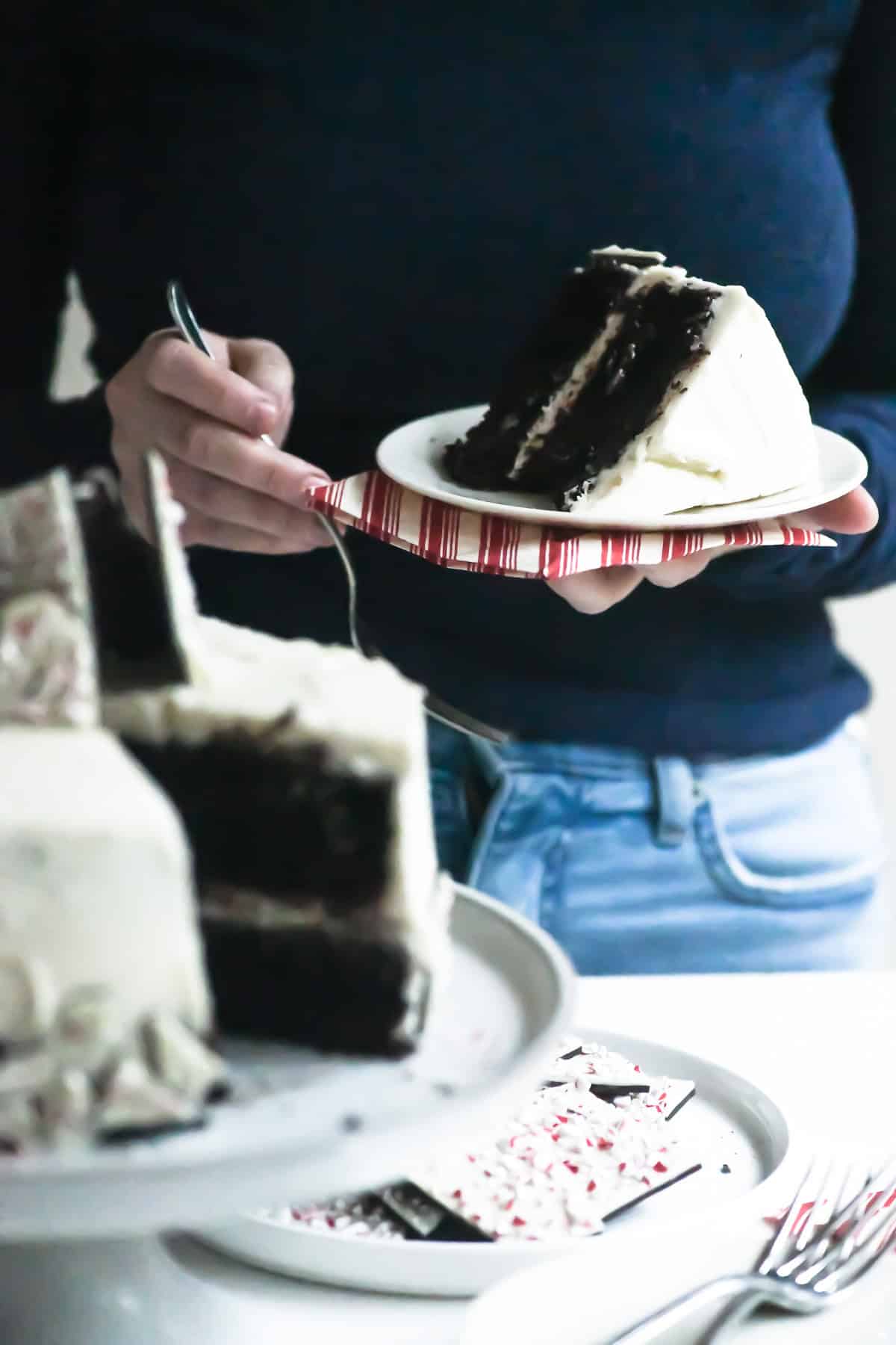 Holding a slice of peppermint bark Christmas cake