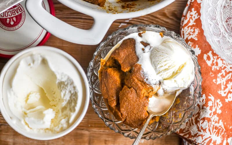 Pumpkin Indian Pudding in a bowl with ice cream.