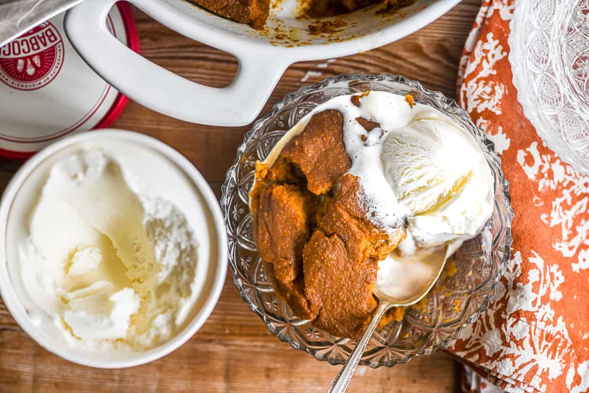 Pumpkin Indian Pudding in a bowl with ice cream.