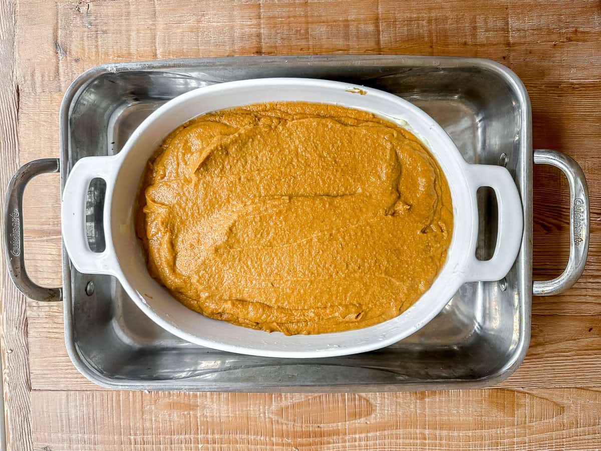 Pumpkin Indian Pudding in a water bath ready to bake.