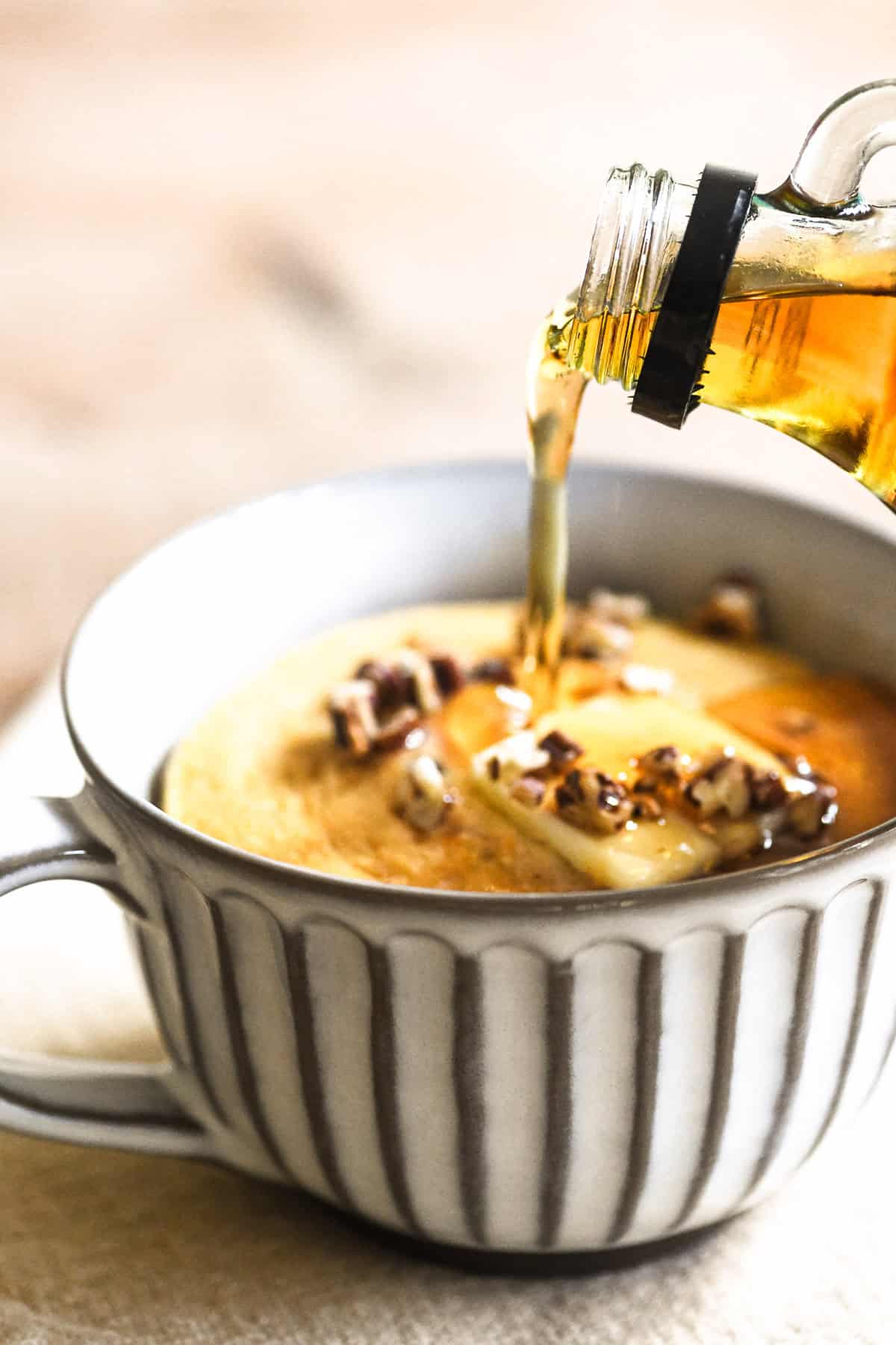 pouring syrup onto a pumpkin pancake bowl.
