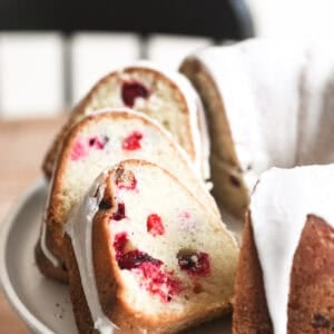 vanilla cranberry bundt cake, sliced on a cake stand.