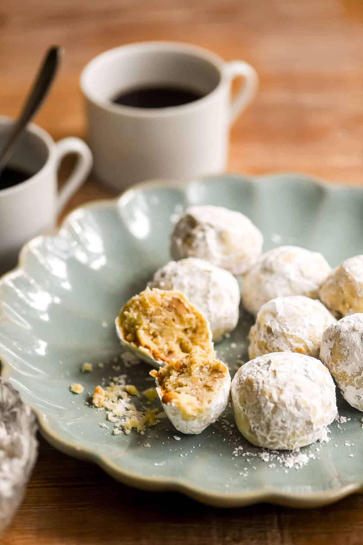 walnut ginger butter balls on a plate with coffee.