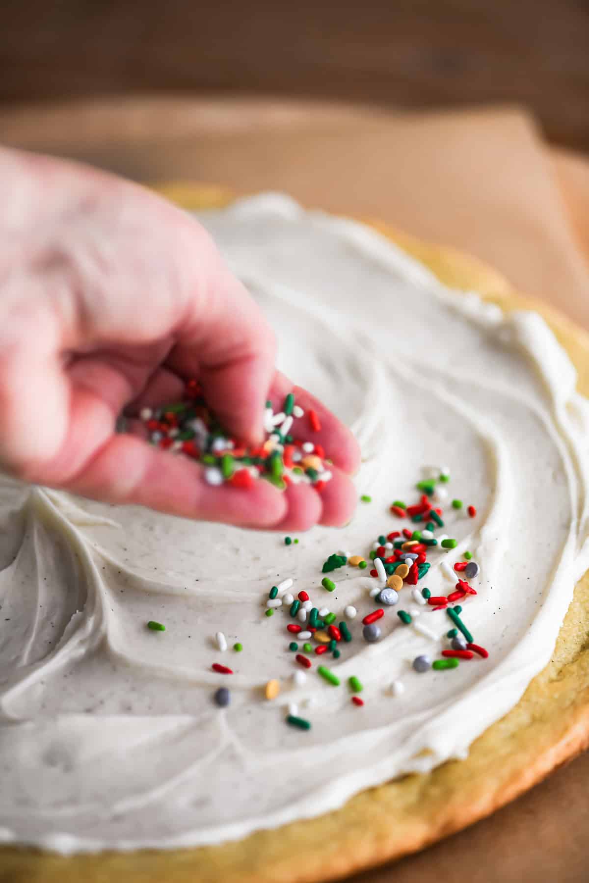 sprinkling sprinkles on a Christmas pizookie