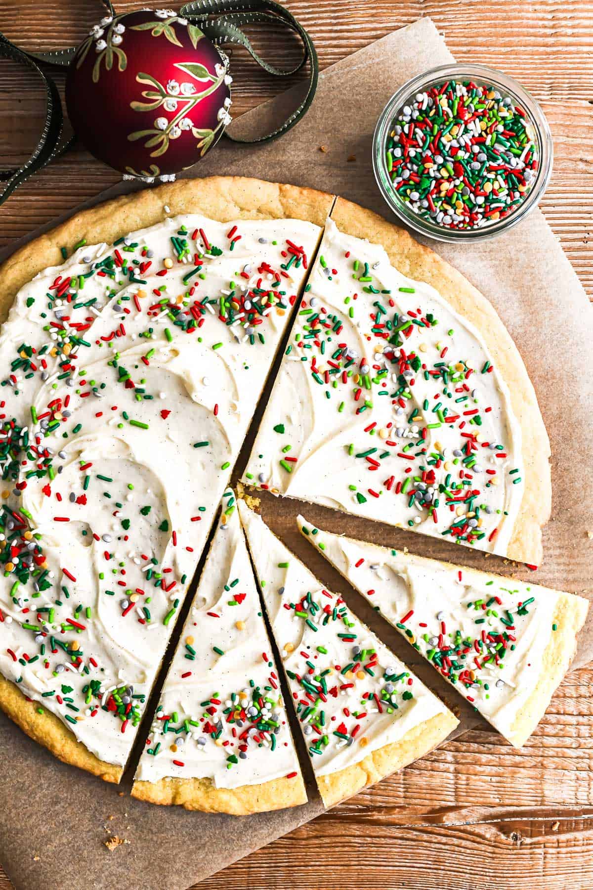 giant Christmas Cookie Pie on a wooden table with piece taken.