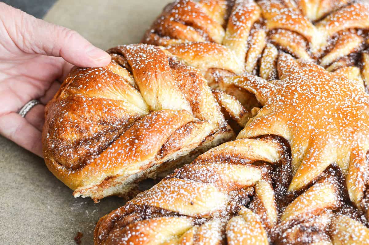 Pulling apart a piece of cinnamon star bread.