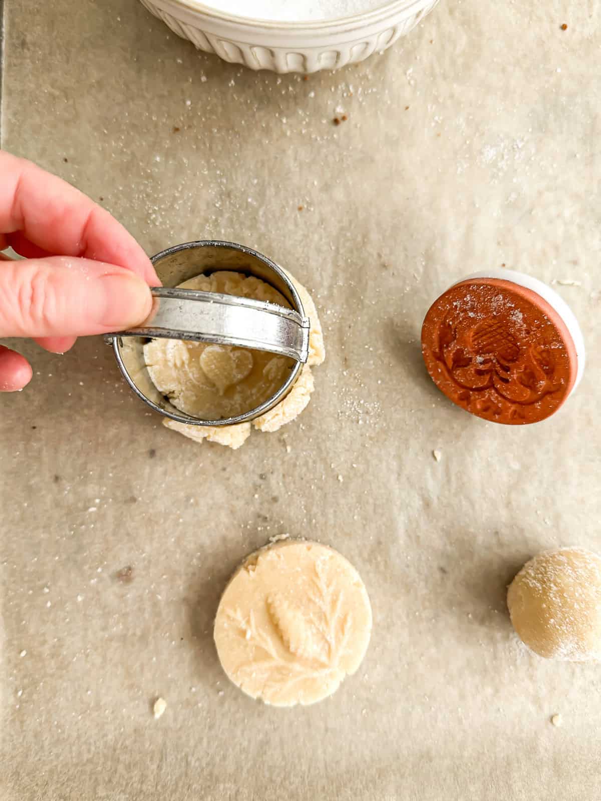Neatening edges of a marzipan shortbread cookie.