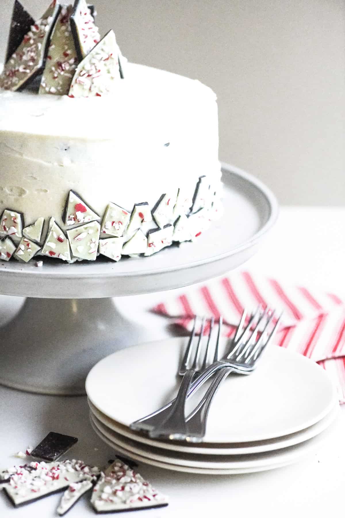 peppermint bark cake on a cake stand with festive napkins.