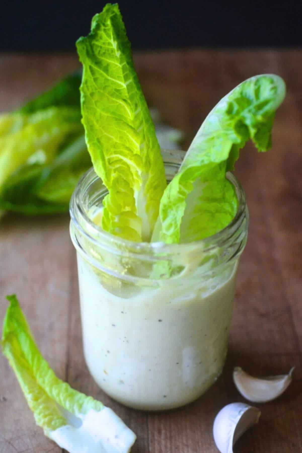 caesar dressing in a jar with lettuce.