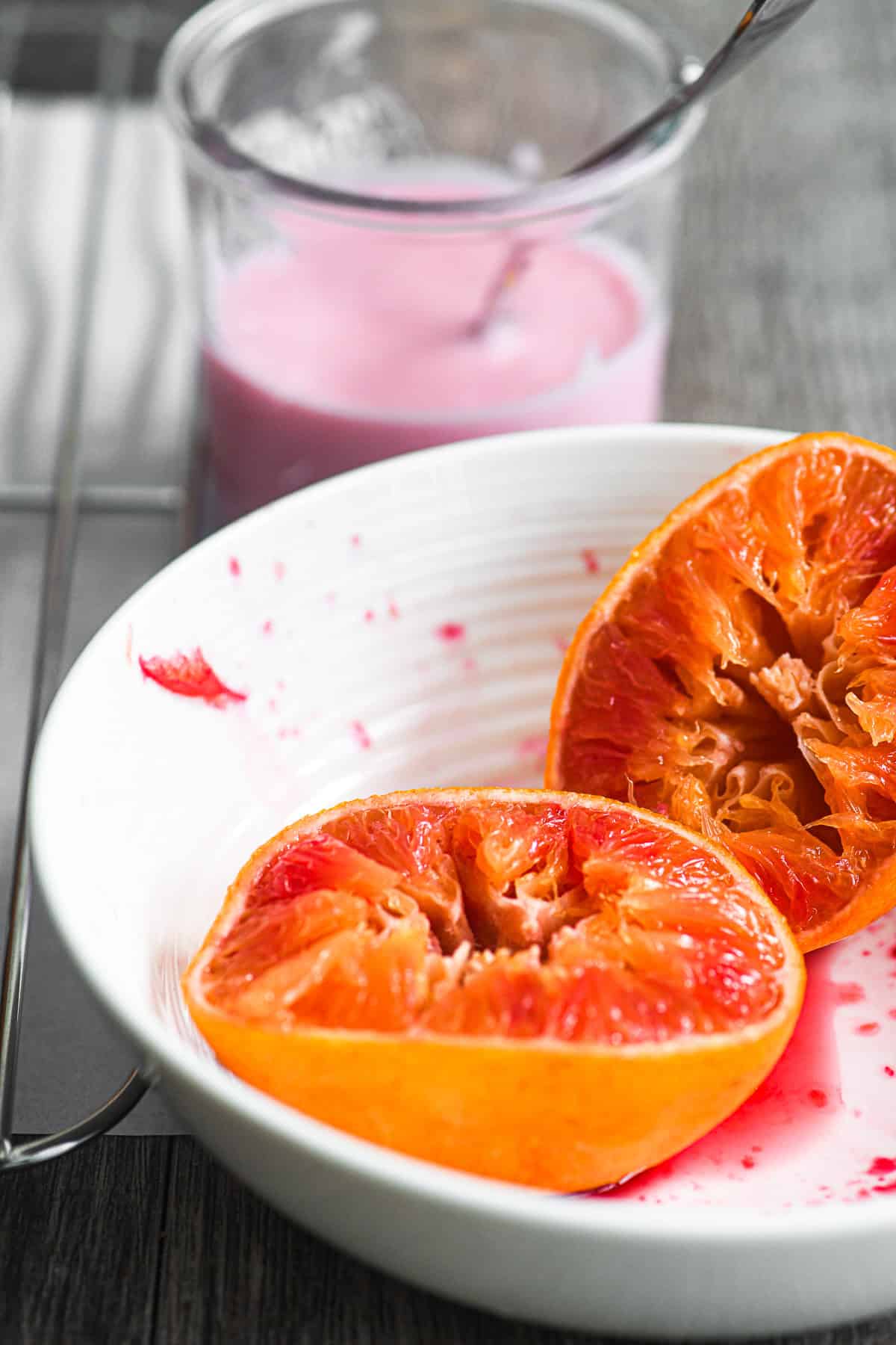 blood oranges, squeezed, in front of a small jar of glaze.