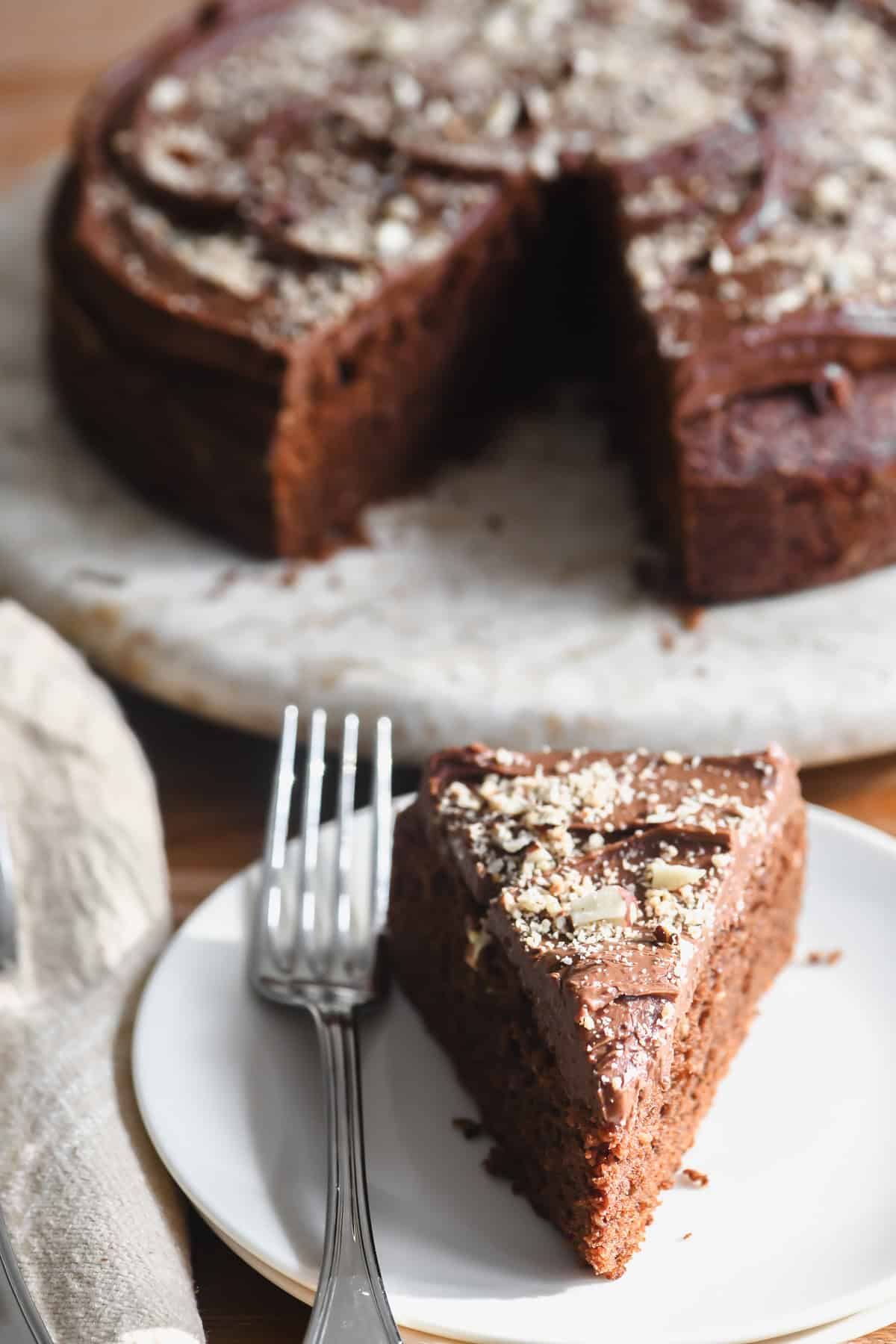 dark chocolate hazelnut cake with slice on a plate with fork.
