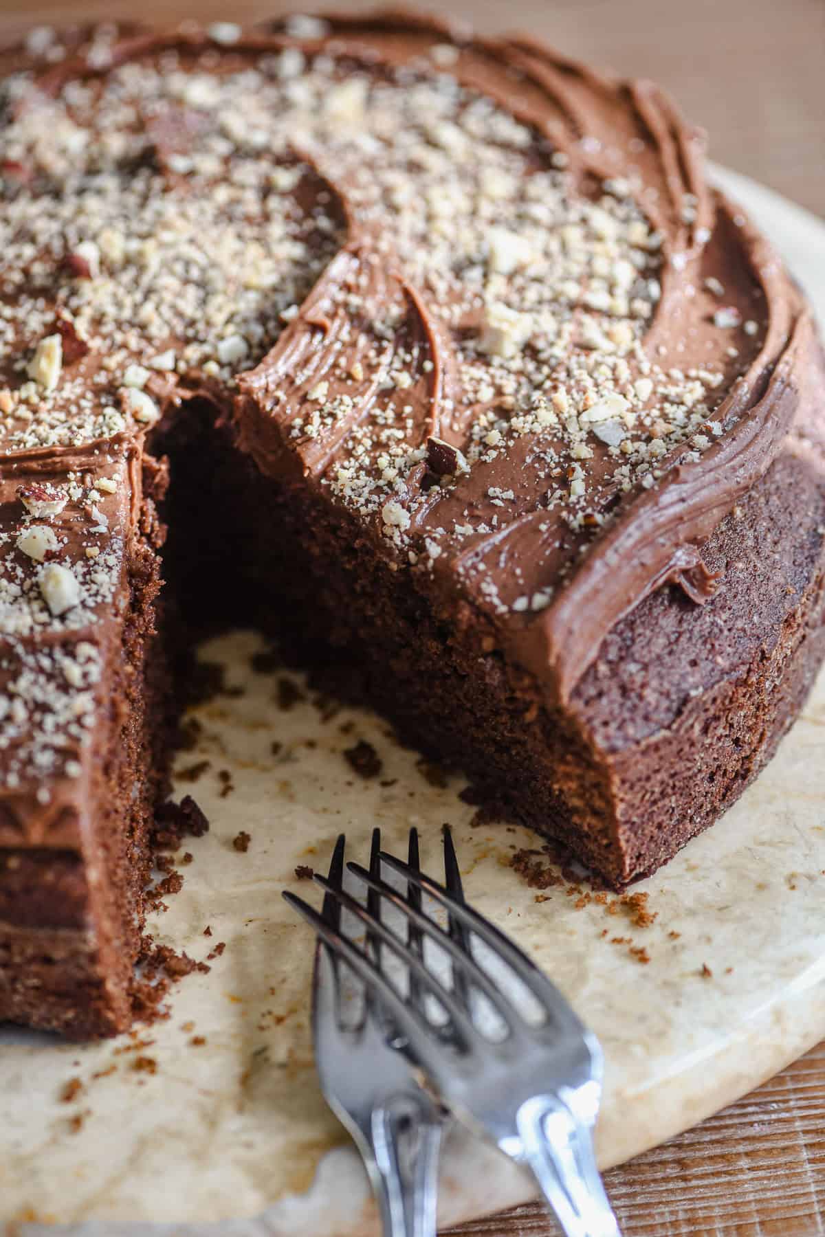 Dark chocolate hazelnut cake with slice taken.