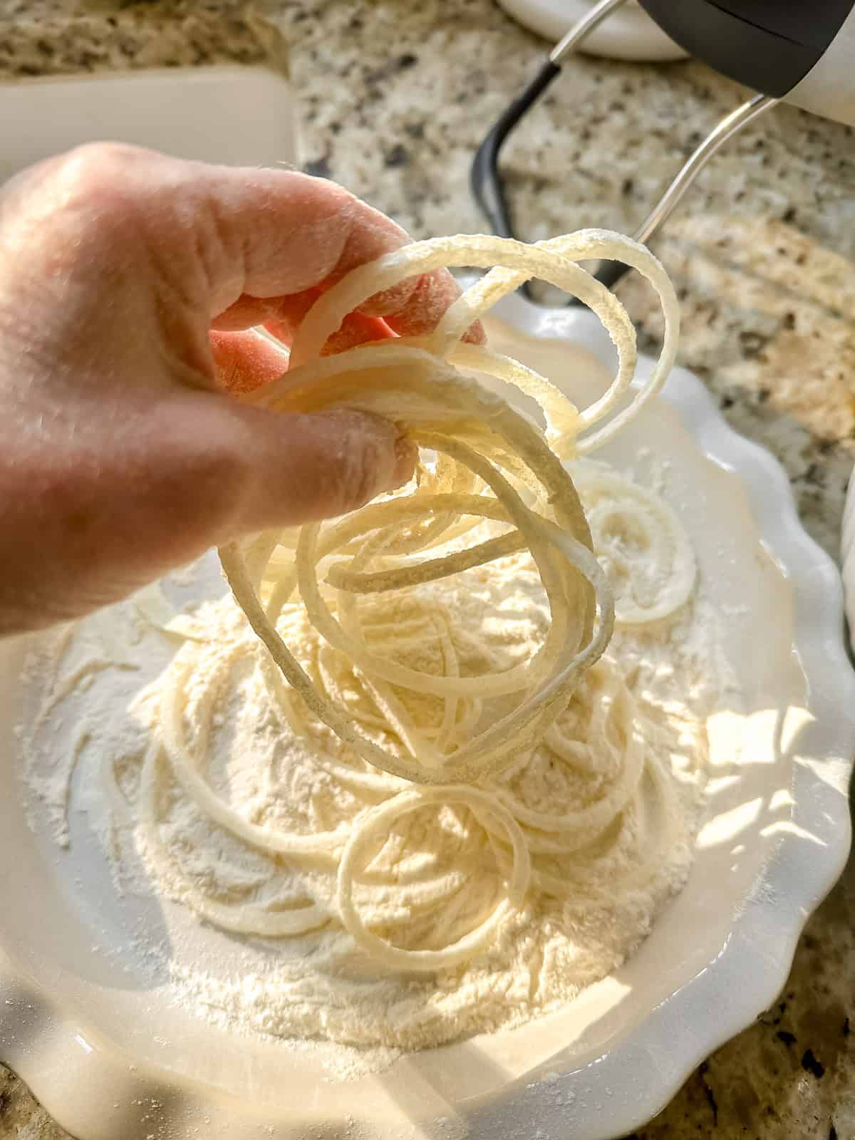 dredging onion strings in flour.