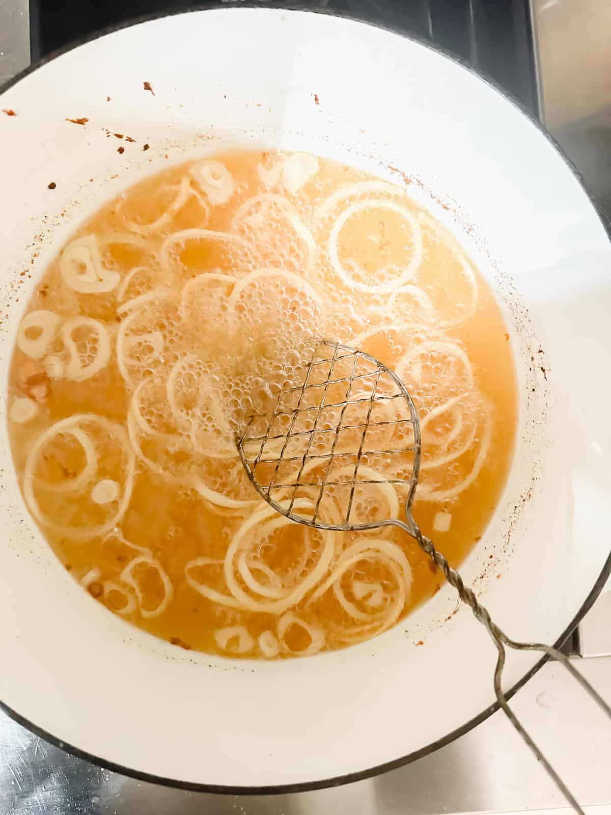 frying onion strings in vegetable oil.