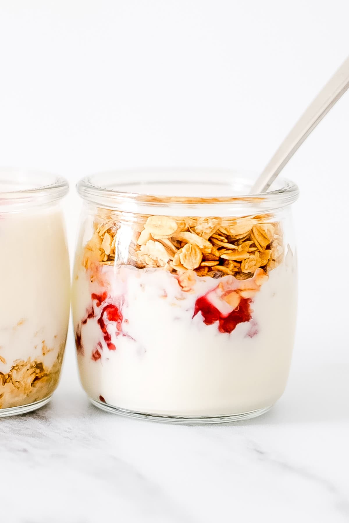 yogurt with fruit and granola in small jar.
