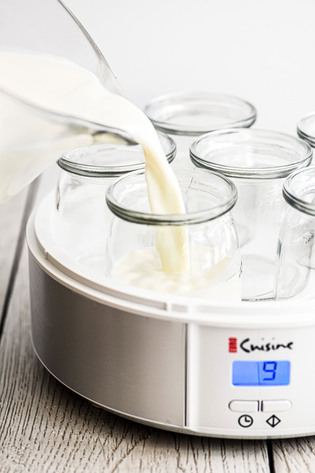Pouring milk into a yogurt maker.