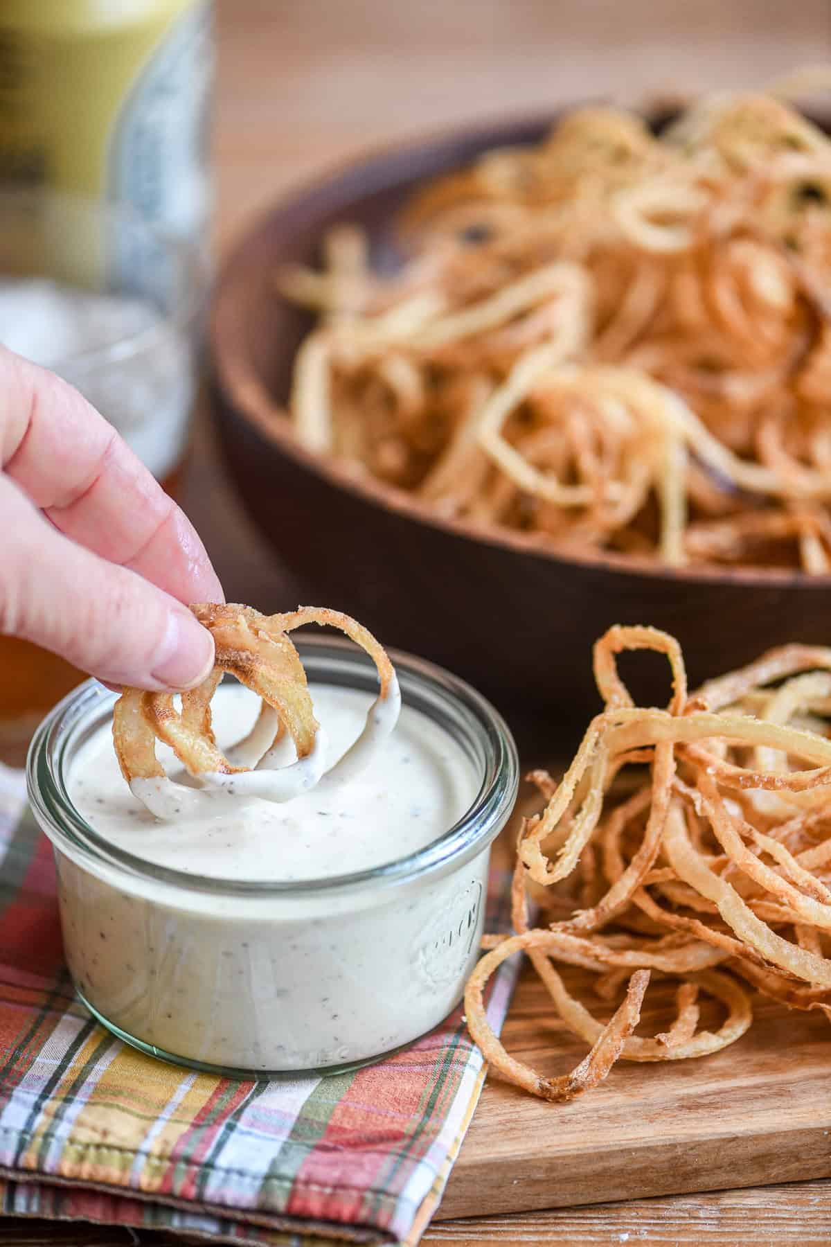 dipping onion strings in a lemony dip.
