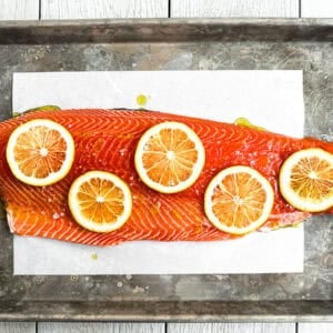 whole side of salmon prepped on a sheet pan.
