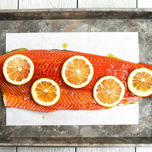 whole side of salmon prepped on a sheet pan.