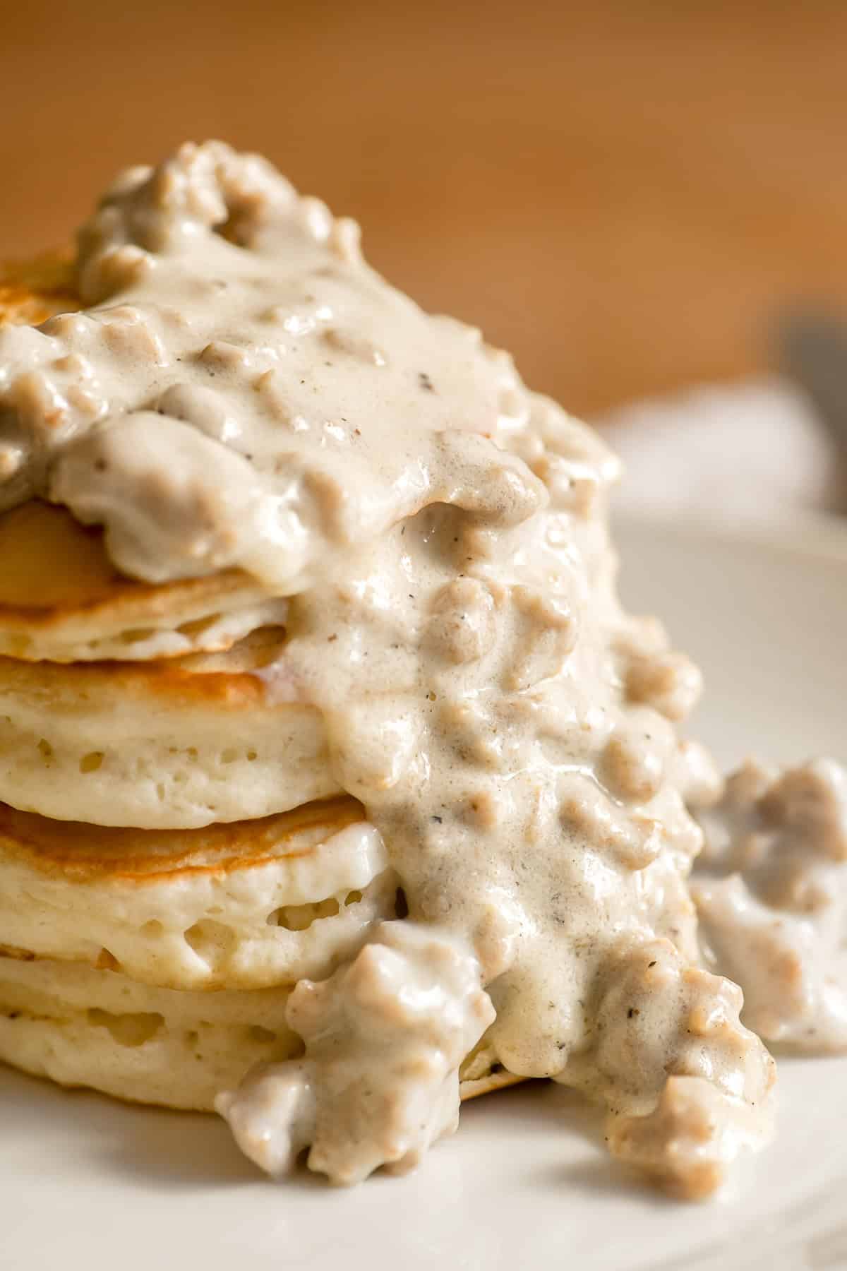 A stack of biscuit pancakes topped with country gravy.