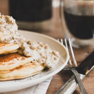 biscuit pancakes with country gravy, coffee in the background.