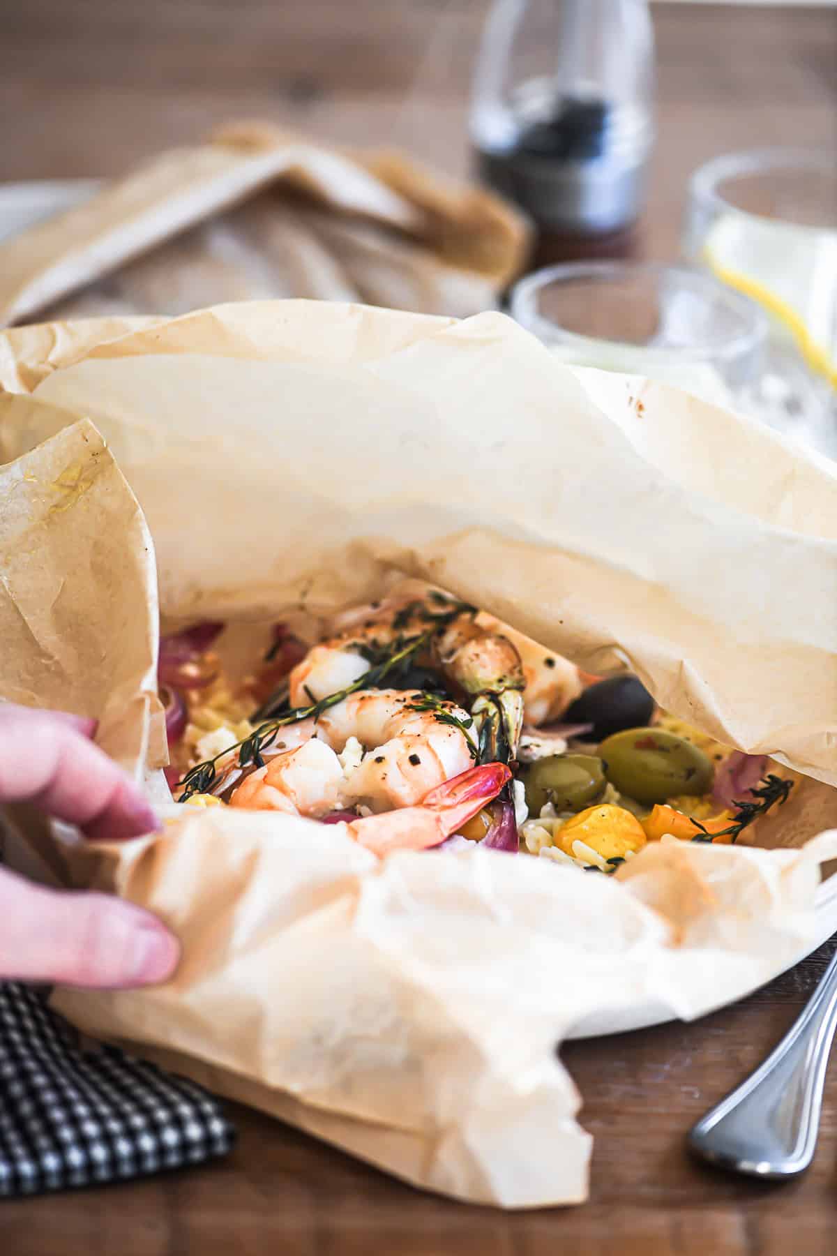 opening a steaming Greek shrimp packet dinner.