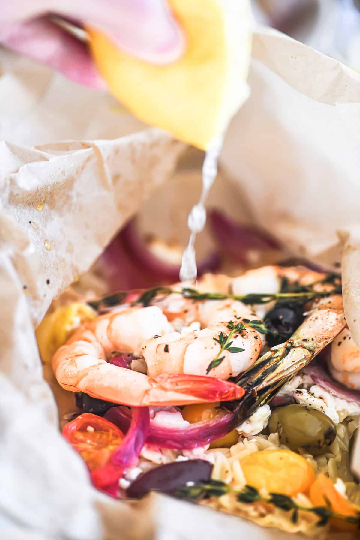 squeezing lemon on a shrimp packet dinner.