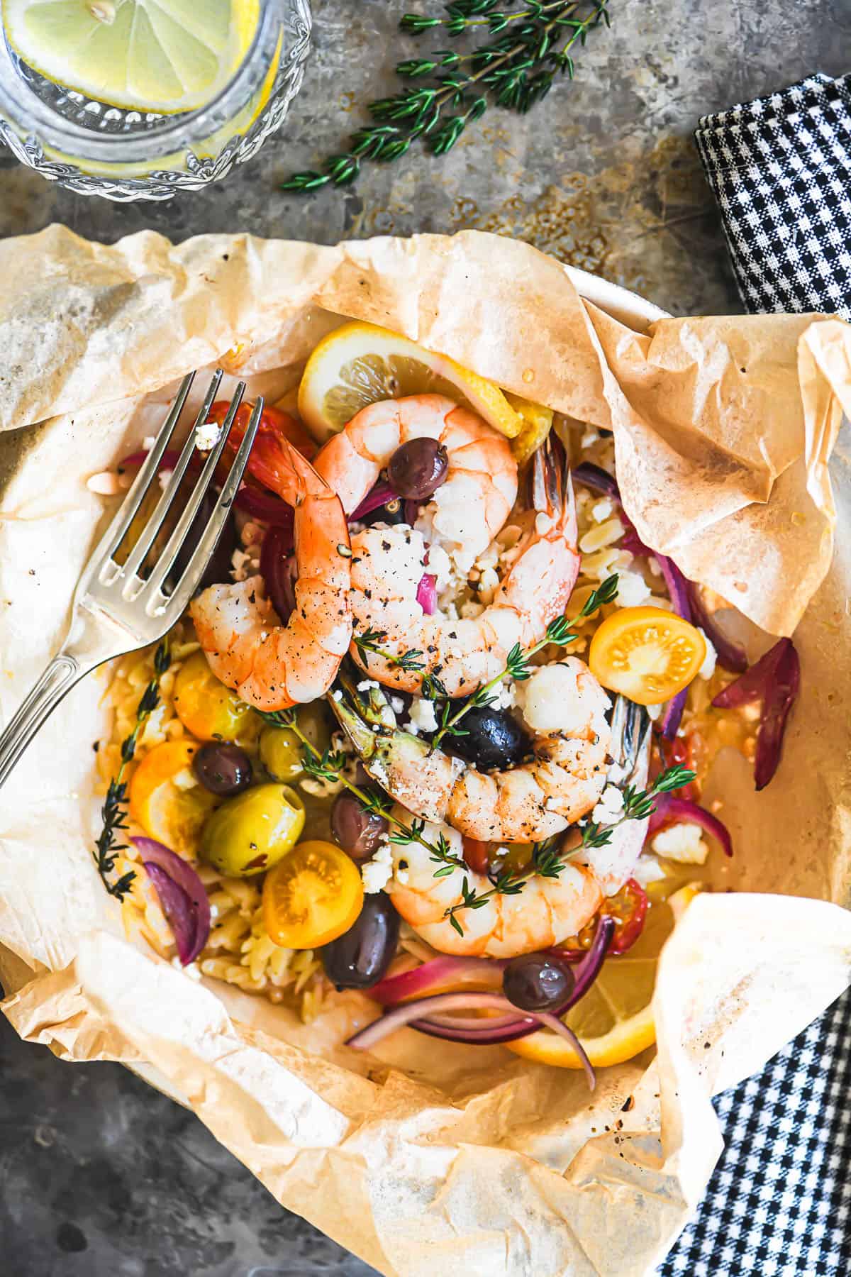 Greek shrimp packet with orzo, unwrapped on a dinner plate.