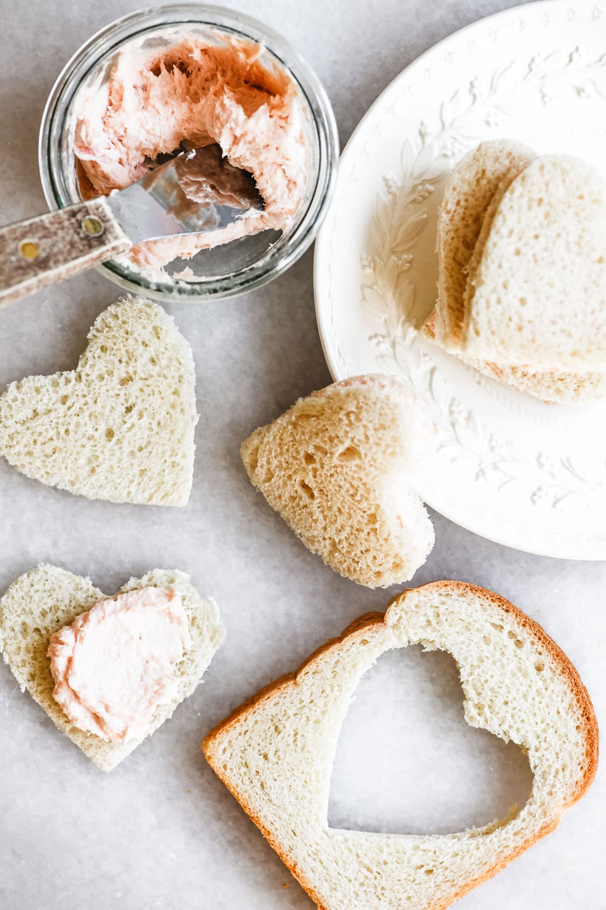 Making heart shaped smoked salmon and cream cheese tea sandwiches.