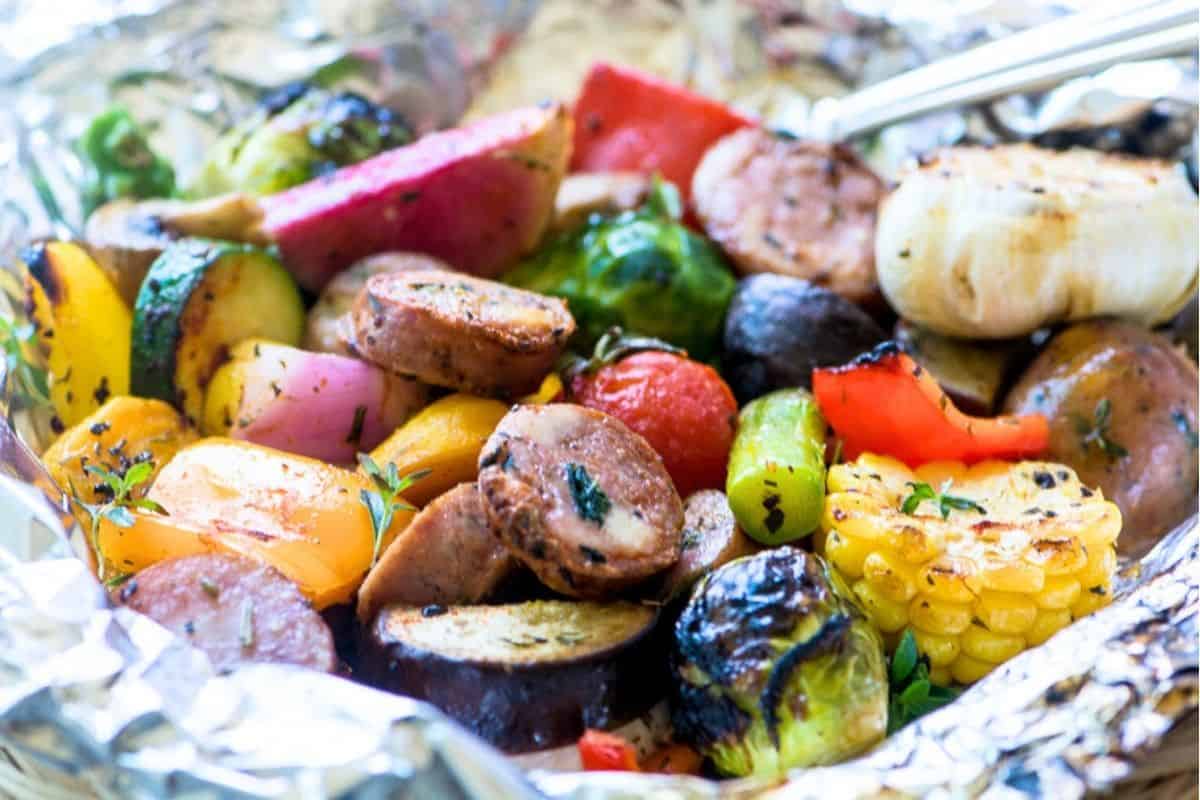 aluminum foil dinner packet with sausage and veggies for the grill.