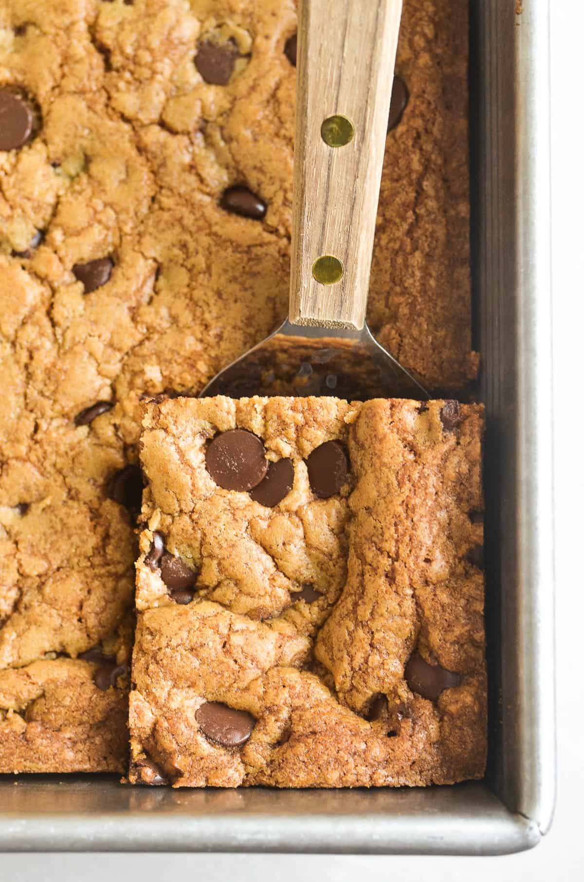 taking a cardamom coffee blondie from the pan.