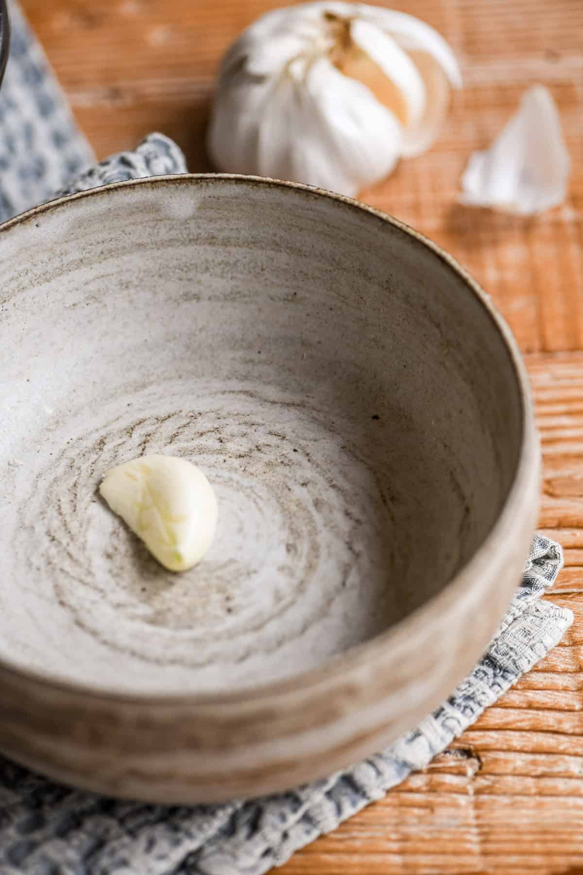 a piece of garlic in a soup bowl for cheese fondue soup.